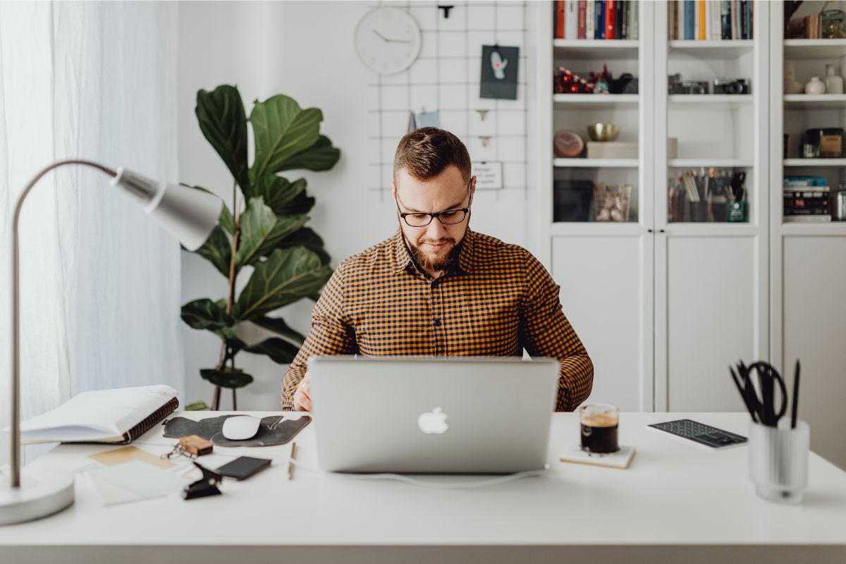 A worker sat in his home office at a desk in front of a laptop
