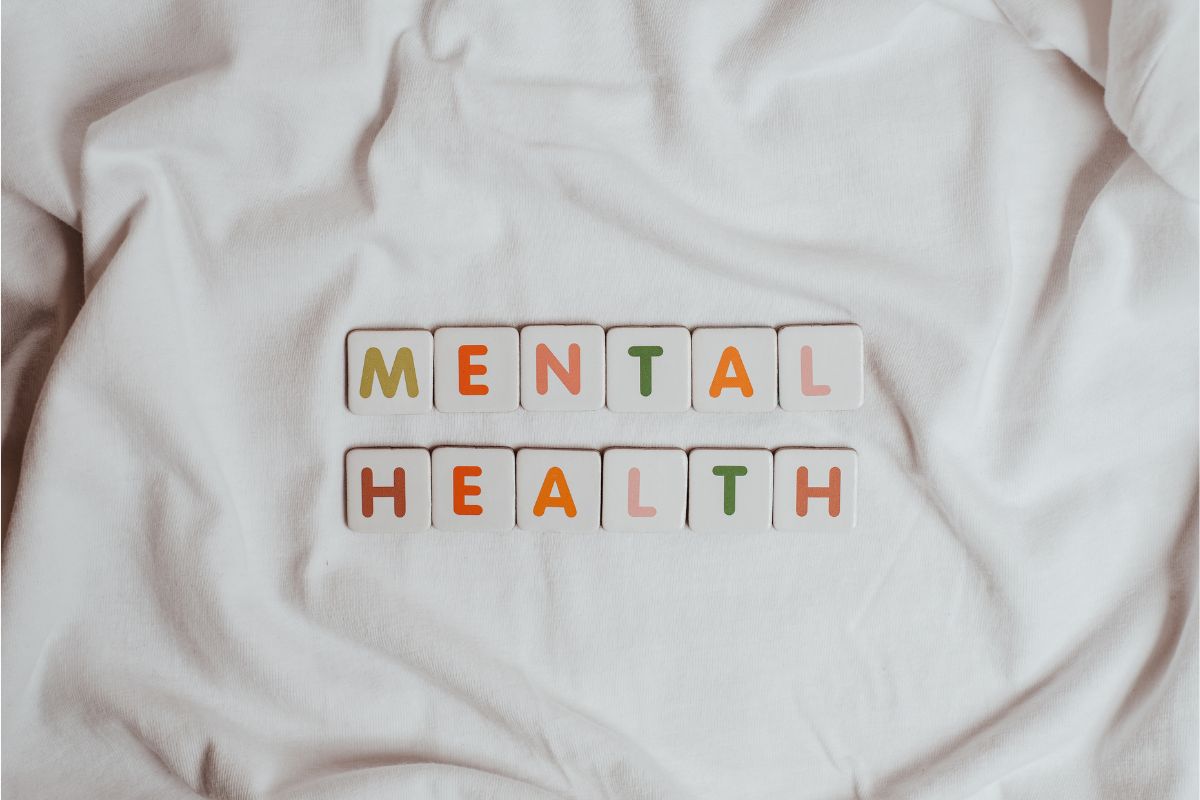 Letter tiles spelling out Mental health on a white ruffled sheet