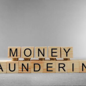 Wooden blocks spelling out Money Laundering with pennies stacked underneath the Money blocks