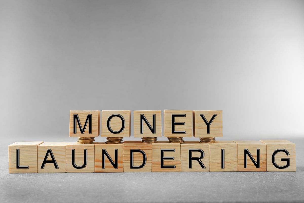 Wooden blocks spelling out Money Laundering with pennies stacked underneath the Money blocks